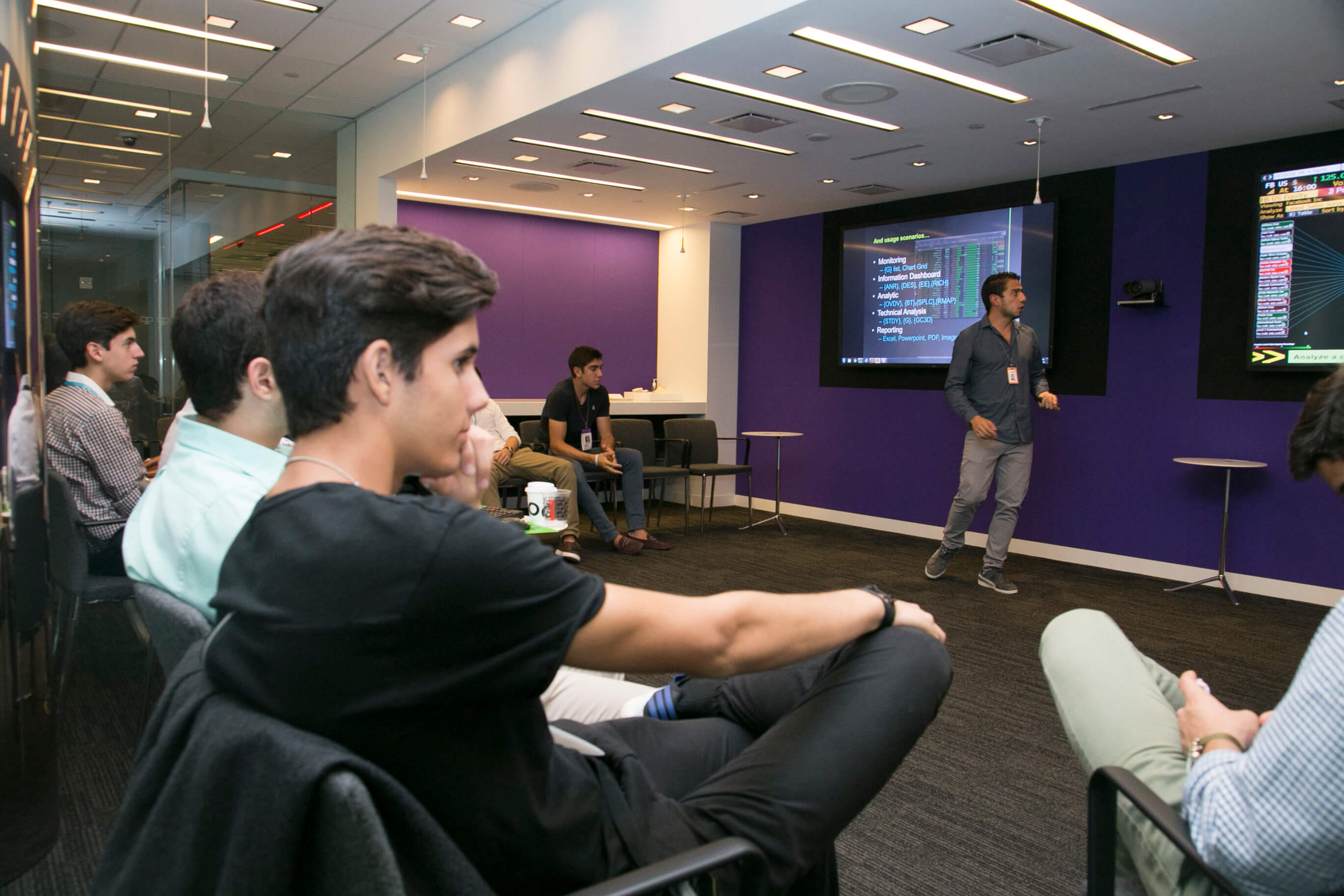 Visionarium students in a presentation room, watching a speaker at the front.