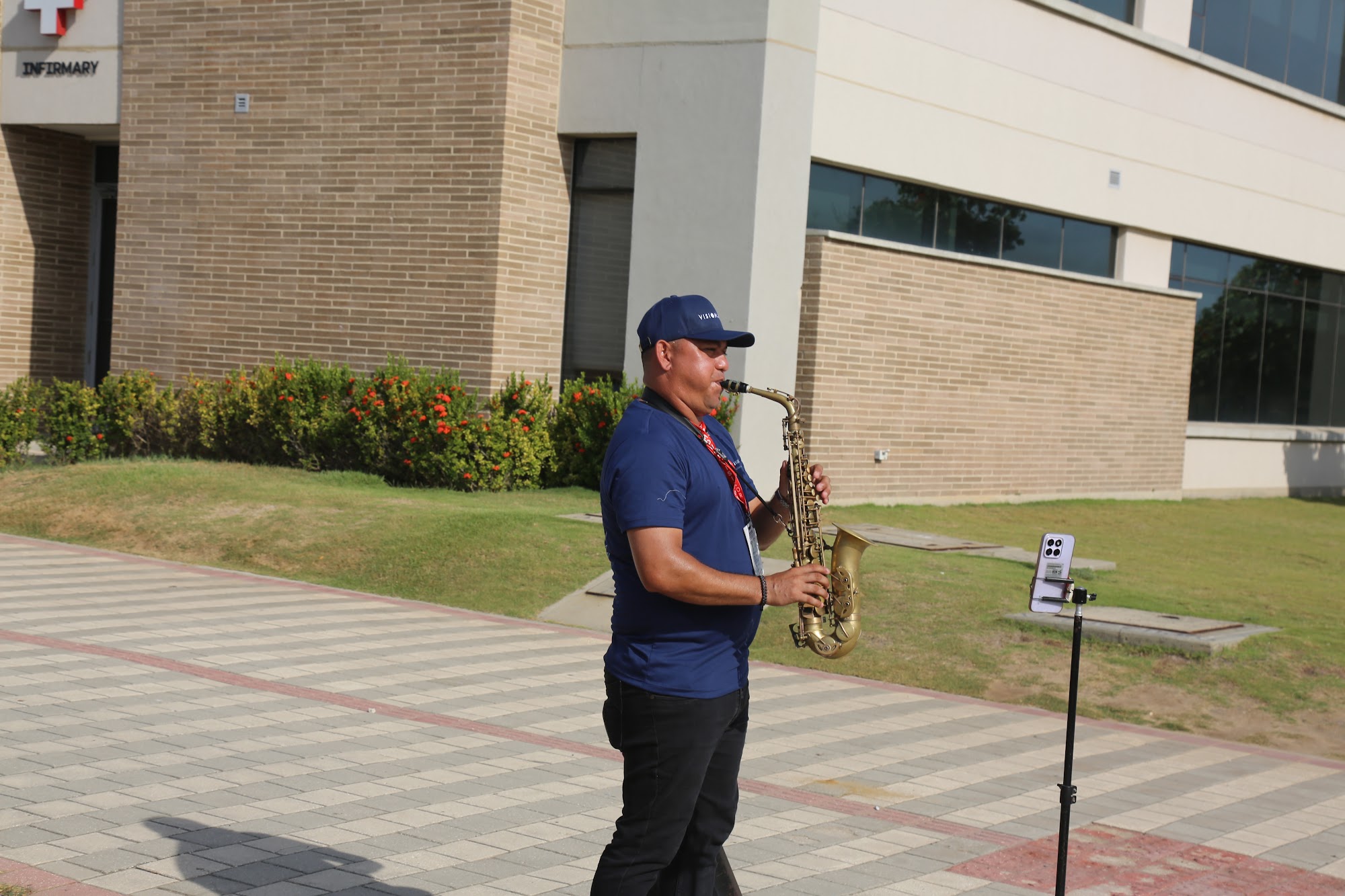A saxophonist plays on the walkway outside the school as the first students arrive.