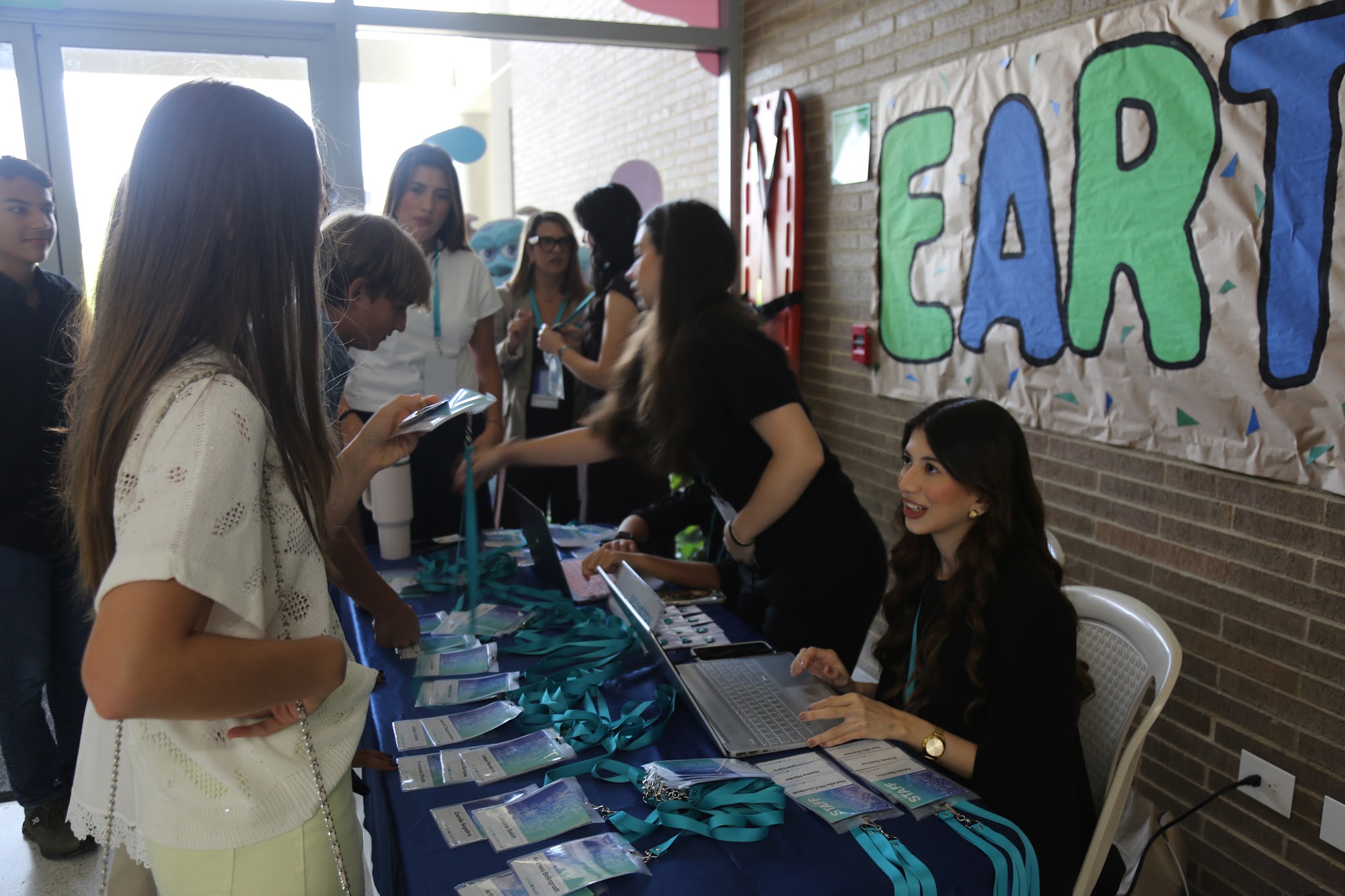 Students collecting their lanyards and badges at the registration table.