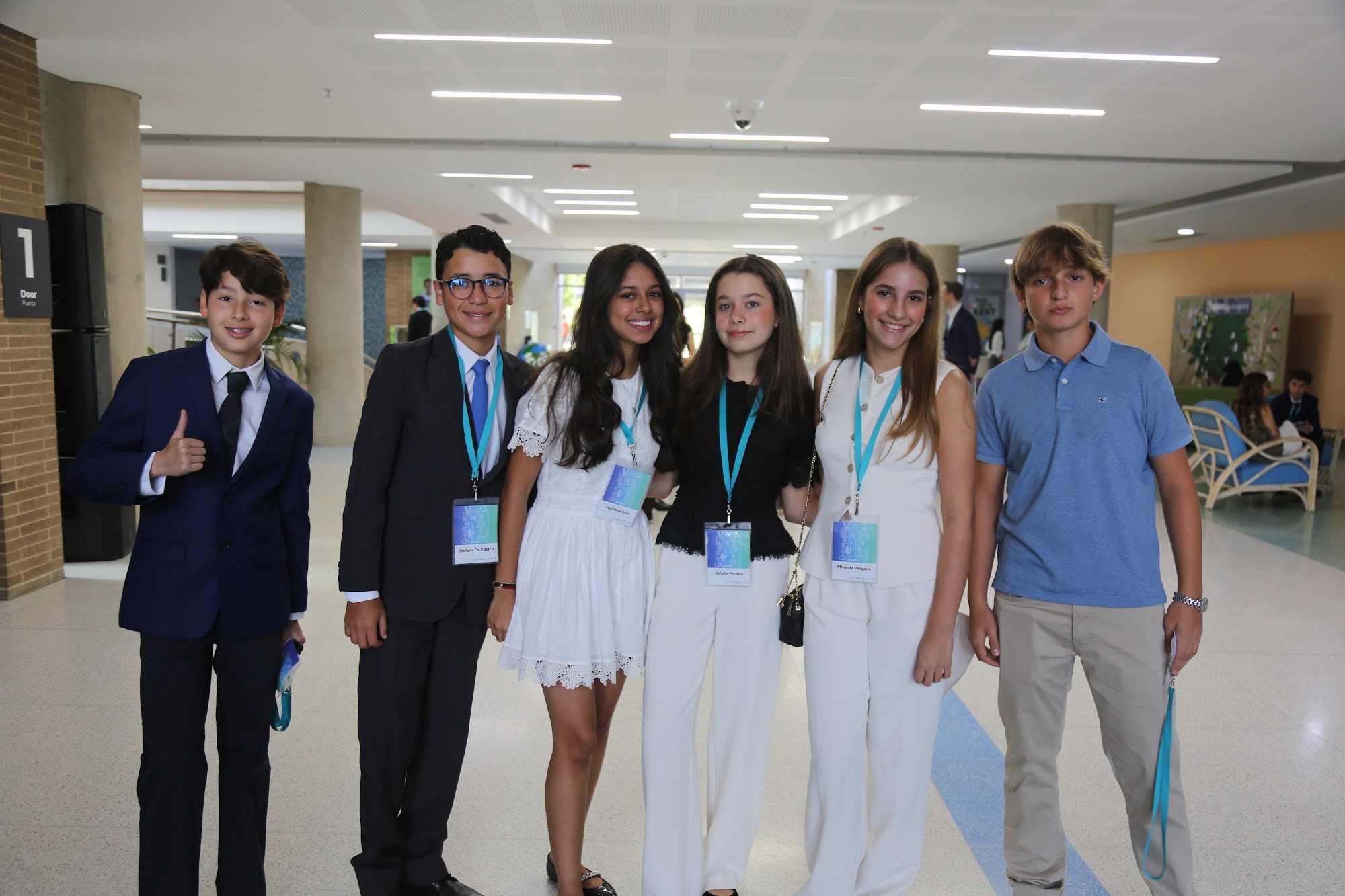 A group of Visionarium students in a school corridor in Barranquilla, badges on, before the first session.