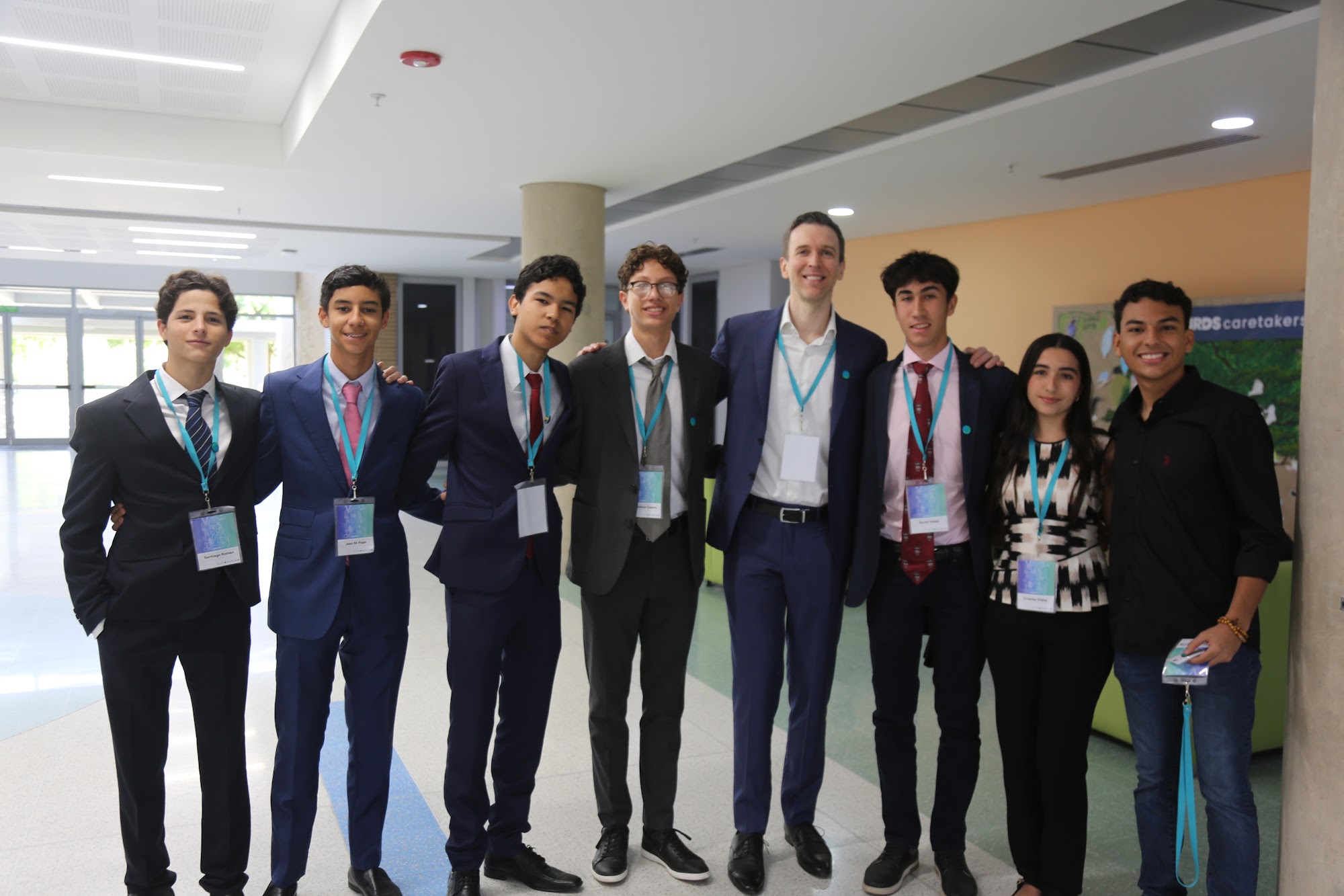 A larger group of students posing together in the corridor.