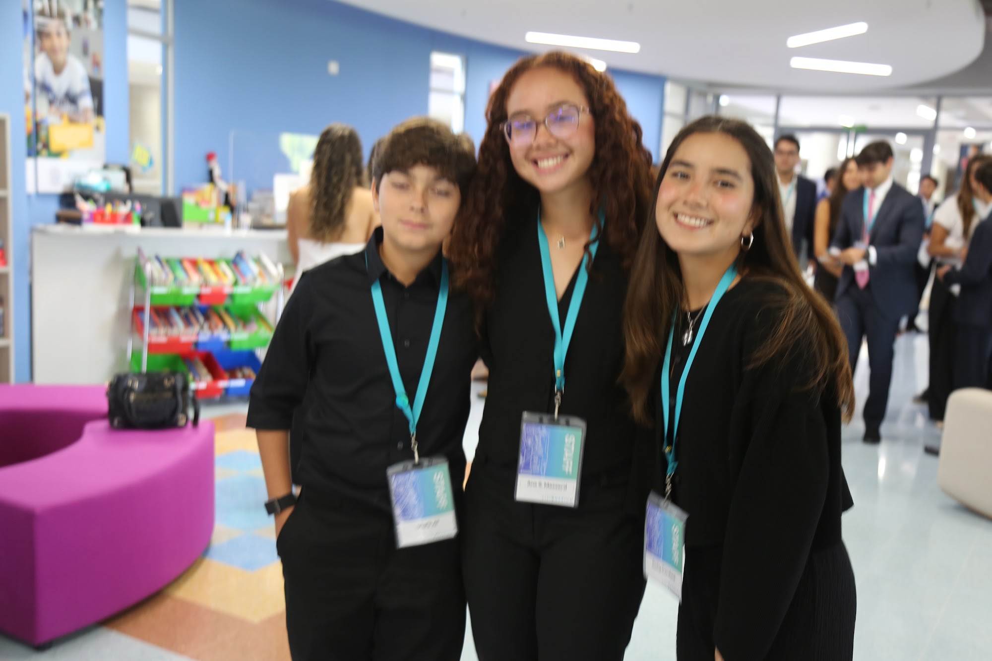 Three students together in the library at the start of the day.