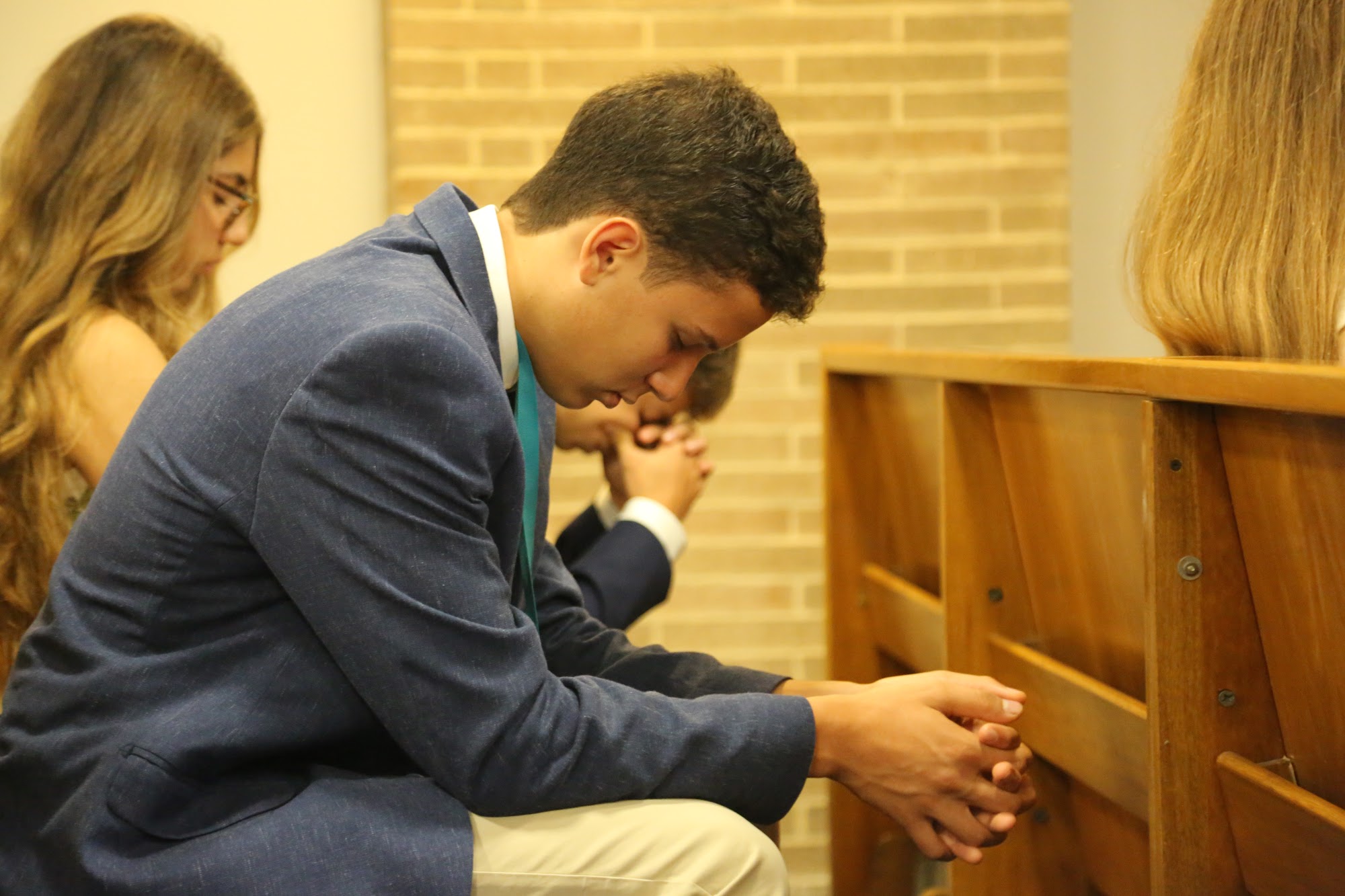 A student with hands folded during the opening ceremony.