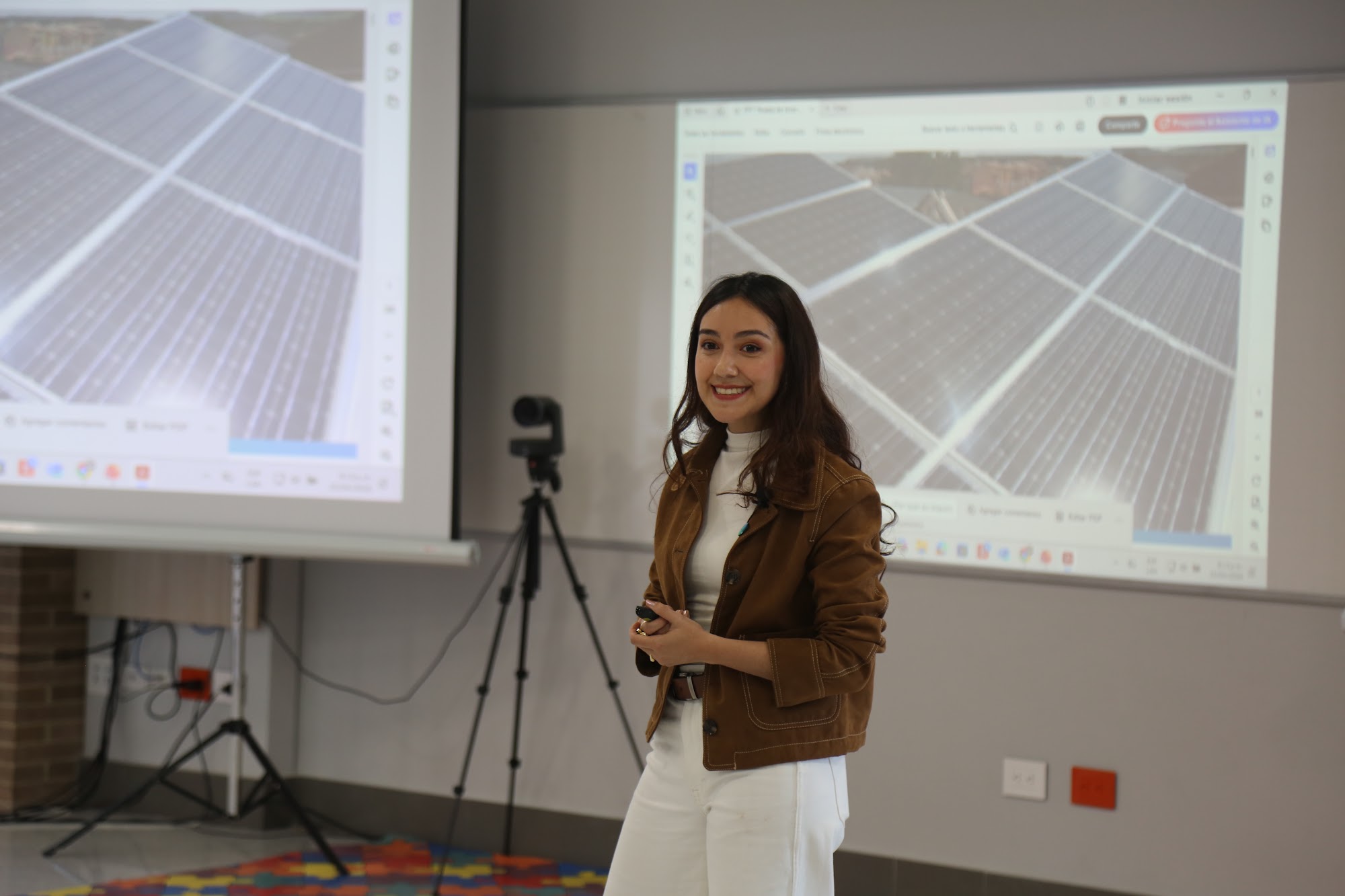 A speaker presenting alongside her slides in the library.