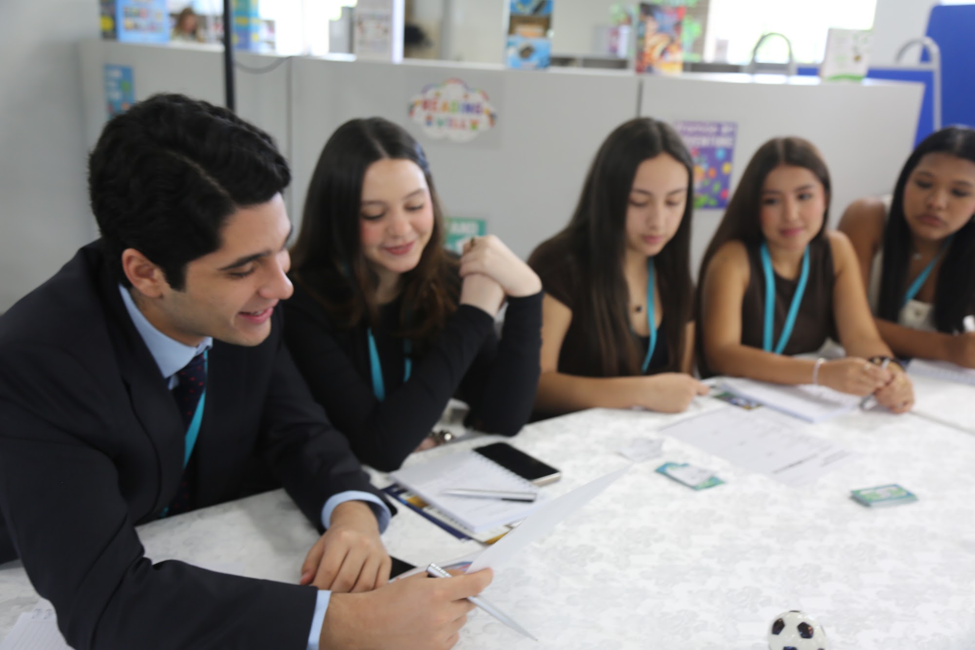 A mentor leaning in to work through an exercise with a group of students.