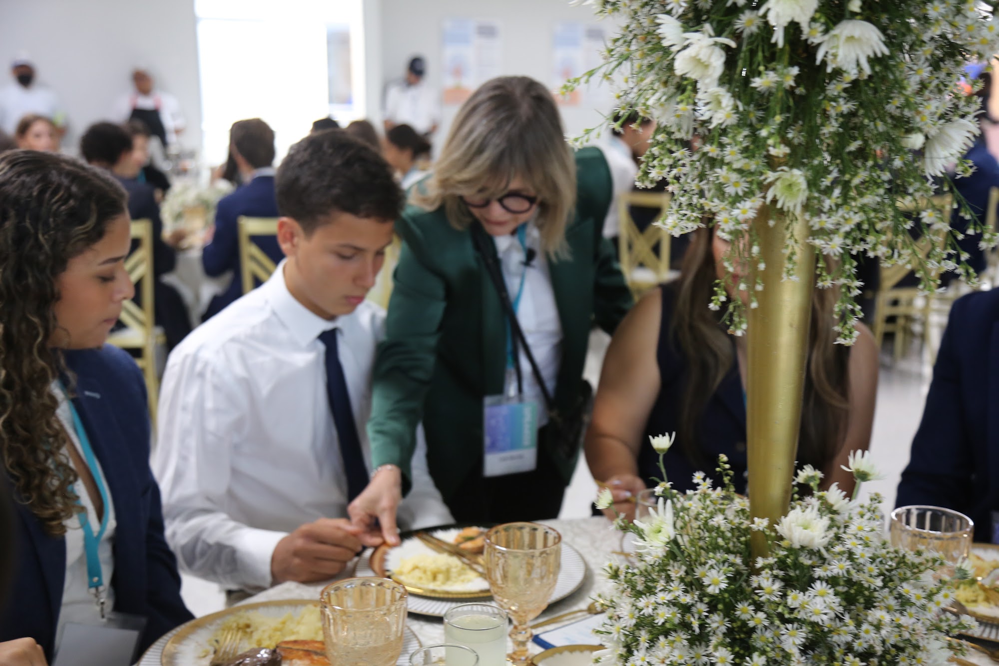 A member of staff serving a student at the table.
