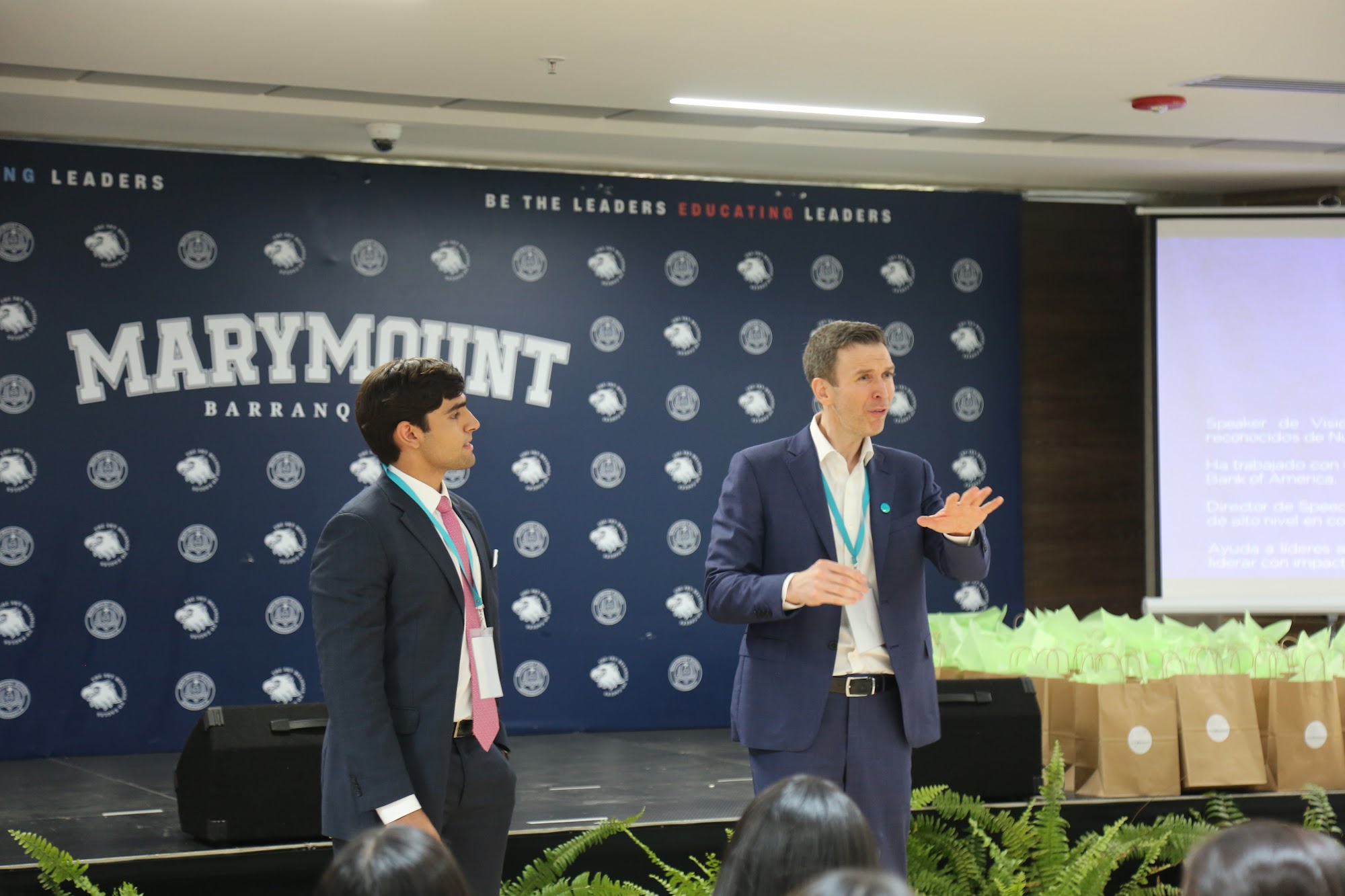 A student on stage being coached through a speech.